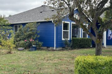 Exterior of a freshly-painted blue house with white trim