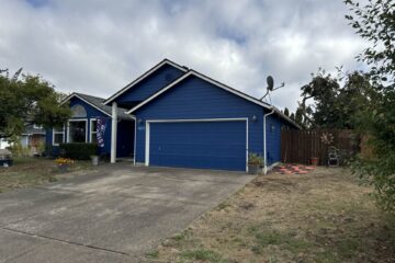 Exterior of a freshly-painted blue house with white trim